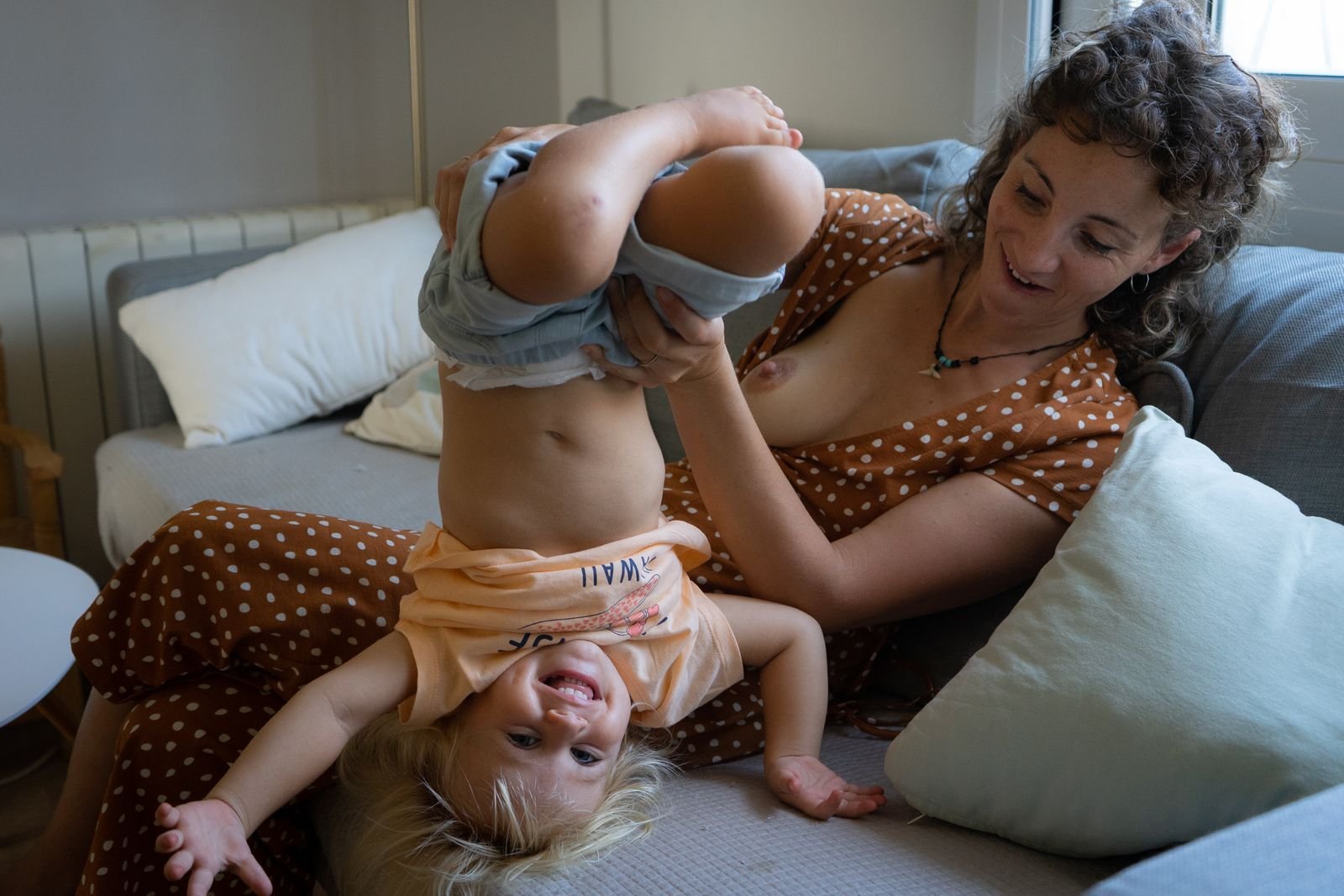 Familia: madre jugando con su hijo en el sofá
