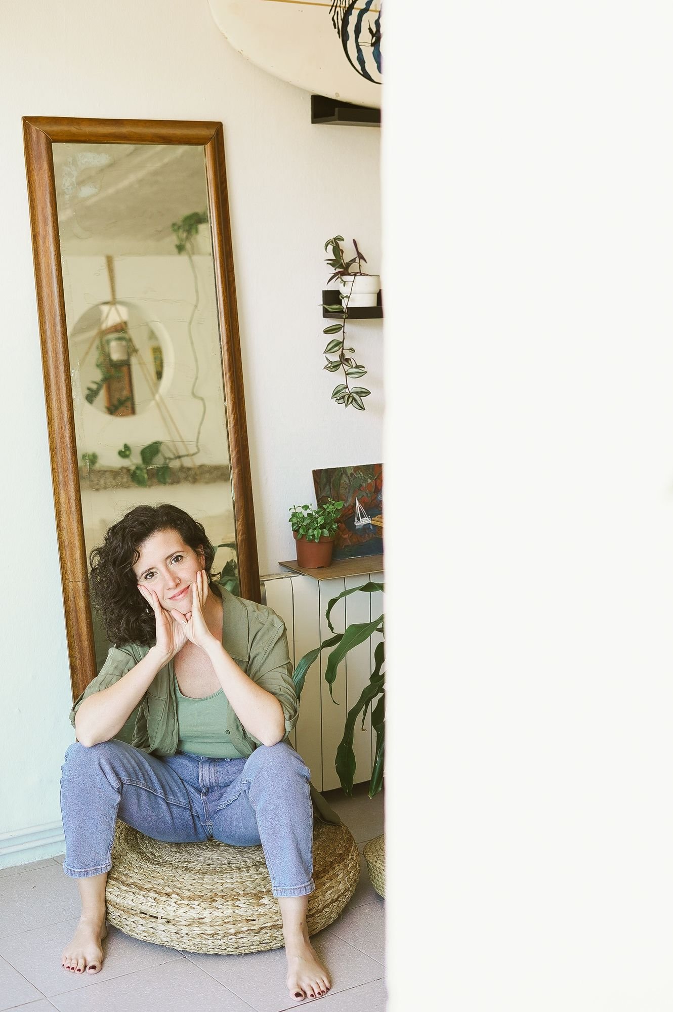 Laura sentada junto a un espejo en su casa, con las manos en la cara